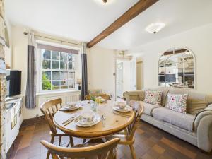 a living room with a table and a couch at Romantic Cottage Cotswolds Parking Wi-Fi in Winchcombe