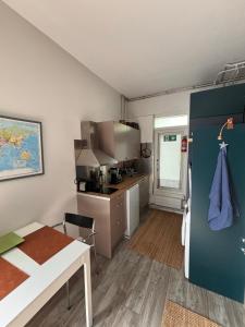 a small kitchen with a table and a refrigerator at Loft style big studio for 2-4 in Pikku Huopalahti in Helsinki