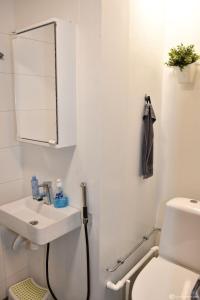 a white bathroom with a sink and a toilet at Loft style big studio for 2-4 in Pikku Huopalahti in Helsinki