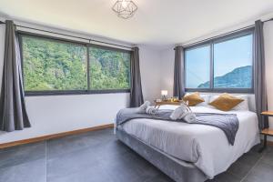 a bedroom with a bed and large windows at Mystic Mountain by Atlantic Holiday in São Vicente