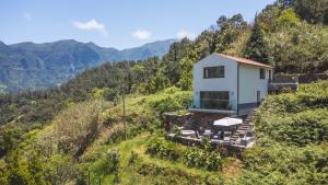 a house on a hill with mountains in the background at Mystic Mountain by Atlantic Holiday in São Vicente