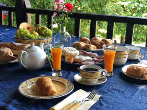 a blue table topped with plates of food and fruit at Aux Deux Lys in Plazac