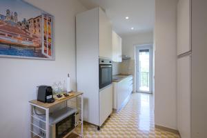 a kitchen with white cabinets and a tile floor at Luxury Suite-Metro Malatesta in Rome