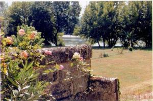 a stone bench with flowers on it in a park at Le Gîte Saint Andre in Sainte-Terre