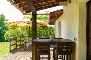 a wooden table and chairs on a deck with an umbrella at Lou Tapata in Estang