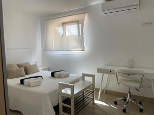 a bedroom with a bed and a desk and a window at V206 Villa Isabel in Son Bou