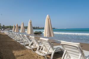 Eine Reihe weißer Stühle und Sonnenschirme an einem Strand in der Unterkunft Tropic Beach Resort Hotel in Side + 112 Fotos