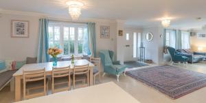 a dining room and living room with a table and chairs at 5 The Sanctuary, Thorpeness - Aldeburgh Coastal Cottages in Thorpeness