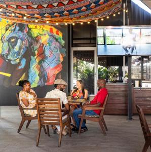 a group of people sitting at a table in a restaurant at ONOMO Hotel Durban in Durban