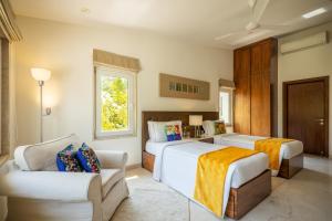 a hotel room with two beds and a couch at Helen's Garden , Bhopal in Bhopal