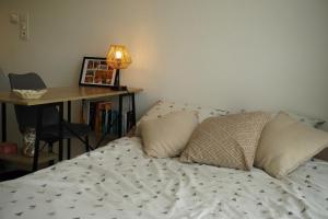 une chambre avec un lit et un bureau avec une lampe dans l'établissement Logement neuf - cœur de ville, à La Roche-sur-Yon