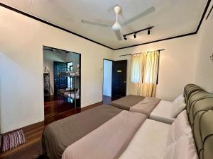 a bedroom with a bed and a ceiling fan at Homestay The Wooden Port Dickson in Port Dickson +41 photos