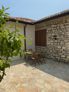 a patio with a table and chairs next to a building at Villa Merkaj, Berat Castle in Berat