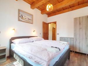 a large bed in a bedroom with a wooden ceiling at Holiday house Woody with private pool - Biró Tours nr 88 in Vonyarcvashegy +24 photos