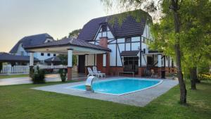 a house with a swimming pool in the yard at Villa D'Astana,A'Famosa Resort Pool-BBQ-Karaoke in Alor Gajah
