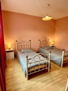 two beds in a room with two tables and two lamps at Gîtes de la Mouette Le Tourteau 5-6 pers in Ravenoville