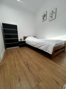 a bedroom with a bed and a wooden floor at Loft Apartments Bielawa "Wschód Słońca" Polskie Como Góry Sowie in Bielawa
