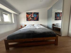 a bedroom with a bed with a painting on the wall at Loft Apartments Bielawa "Wschód Słońca" Polskie Como Góry Sowie in Bielawa