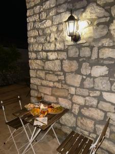 a table with food and a light on a stone wall at Villa Merkaj, Berat Castle in Berat