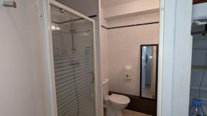 a bathroom with a toilet and a glass shower at Pau'Ze in Idron