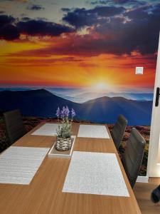 a dining room with a table with a sunset mural at Loft Apartments Bielawa "Wschód Słońca" Polskie Como Góry Sowie in Bielawa
