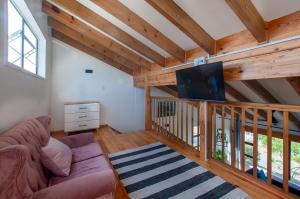 a living room with a couch and a flat screen tv at The Whalehouse in Wilderness