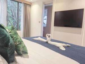a stuffed animal on a bed with a flat screen tv at 竹光别院 Bamboo Radiance Villa in Ban Thalat Choeng Thale