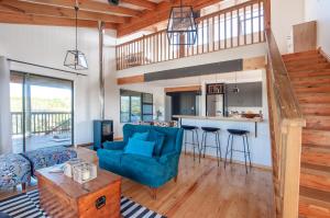 a living room with a blue couch and a kitchen at The Whalehouse in Wilderness