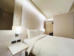 Rúm í herbergi á 新仕飯店-New City Hotel
