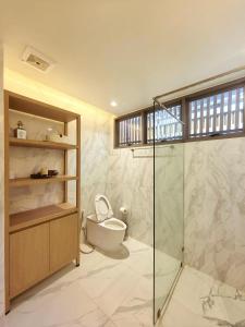 a bathroom with a toilet and a glass shower at 竹光别院 Bamboo Radiance Villa in Ban Thalat Choeng Thale