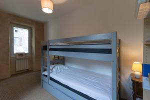 a bedroom with two bunk beds and a window at Maison de village - l'Externat in Laurac-en-Vivarais