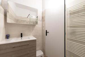 a white bathroom with a sink and a mirror at Maison de village - l'Externat in Laurac-en-Vivarais +15 photos