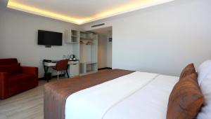 a hotel room with a bed and a chair and a desk at Petra Hotel Trabzon in Trabzon