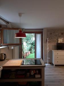 une cuisine avec une grande fenêtre et un îlot central dans l'établissement Casa Valle - Lago di Garda, à Brenzone