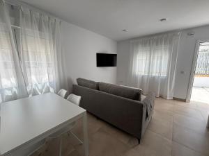 a living room with a couch and a table at Alojamientos VICTORIA MAR-CHIPIONA- in Chipiona