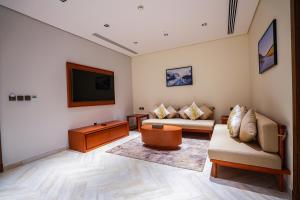 a living room with two couches and a flat screen tv at Vivian Park El Raeid Hotel in Riyadh