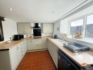 a kitchen with white cabinets and a sink and a window at West Twice Brewed, Bardon Mill - Pet Friendly in Bardon Mill