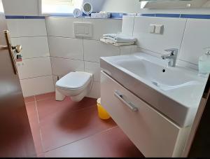 a white bathroom with a toilet and a sink at Ferienwohnung Königswinter in Königswinter