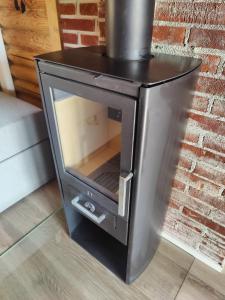 a stove with its door open next to a brick wall at Cabin Pikku Saana in Kilpisjärvi