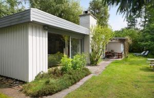 un capanno bianco con un patio e un tavolo di Holiday Home Følfodvejen Gedser I a Gedser