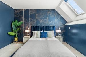 Un dormitorio con una cama grande con paredes azules. en Hotel Odeon Apartments and Rooms I Self Check In, en Viena
