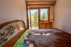 um quarto com uma cama e uma janela grande em Apartamentos Formigal em Formigal