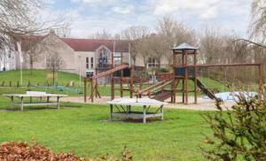 a park with two tables and a playground at Zeer comfortabel vakantiehuis op kleinschalig park 6 personen in Ewijk