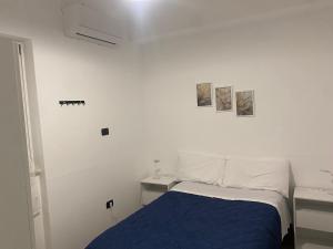 a bedroom with a blue bed and a white wall at Casotta Home in Gravina in Puglia