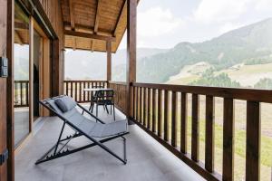 a rocking chair on a porch with a view of mountains at Baumannhof in Sarntal