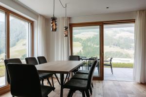 a dining room with a table and chairs and a large window at Baumannhof in Sarntal