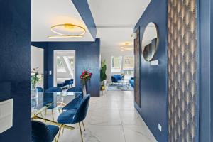 Un pasillo con una mesa de cristal y sillas azules. en Hotel Odeon Apartments and Rooms I Self Check In, en Viena