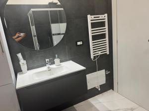 a person taking a picture of a bathroom with a sink at Trilocale a pochi passi dal mare in Martinsicuro +1 photo