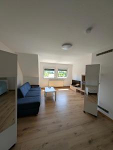 ein Wohnzimmer mit einer blauen Couch und einem Tisch in der Unterkunft Wildemannstraße X in Seesen