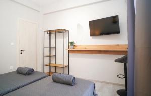 una camera da letto con due letti e una TV a parete di Elarion Elegant Port Apartment a Città di Corfù